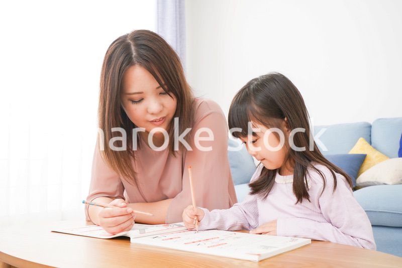 お母さんと一緒にお勉強をする小さな女の子
