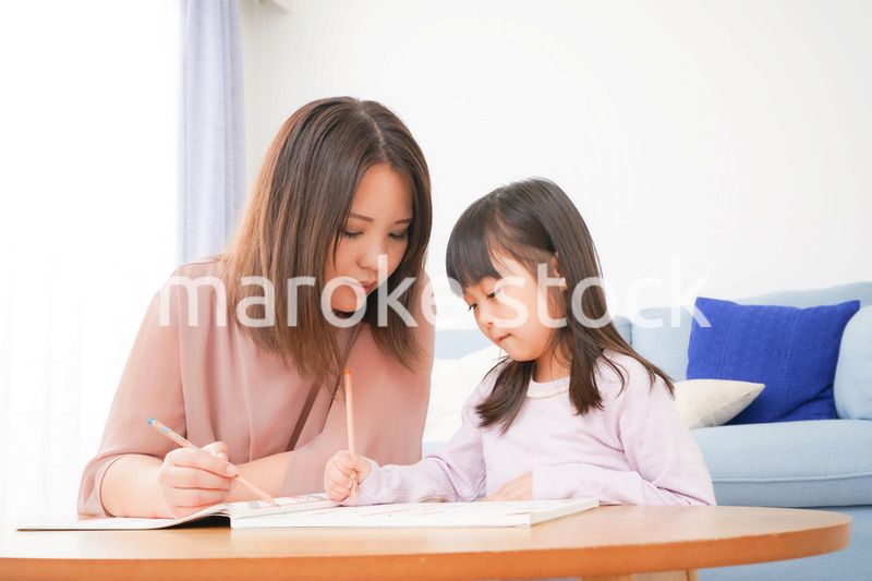 お母さんと一緒にお勉強をする小さな女の子