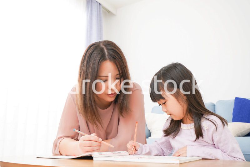 お母さんと一緒にお勉強をする小さな女の子