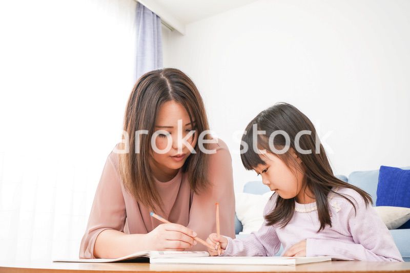 お母さんと一緒にお勉強をする小さな女の子