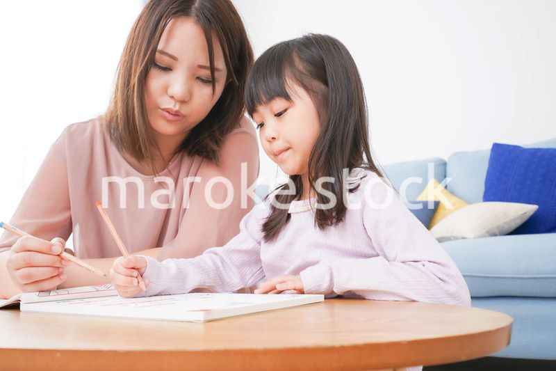 お母さんと一緒にお勉強をする小さな女の子