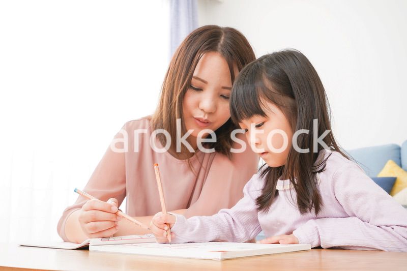 お母さんと一緒にお勉強をする小さな女の子