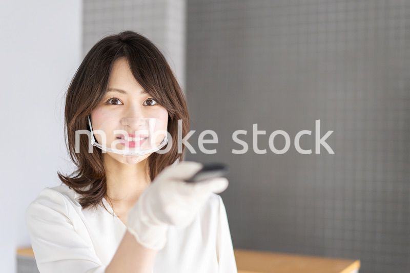 感染拡大防止のためにお客様の体温を計測するスタッフ