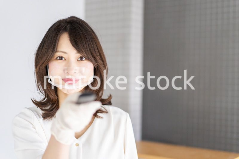 感染拡大防止のためにお客様の体温を計測するスタッフ