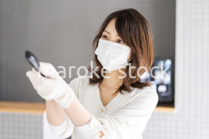 感染拡大防止のためにお客様の体温を計測するスタッフ