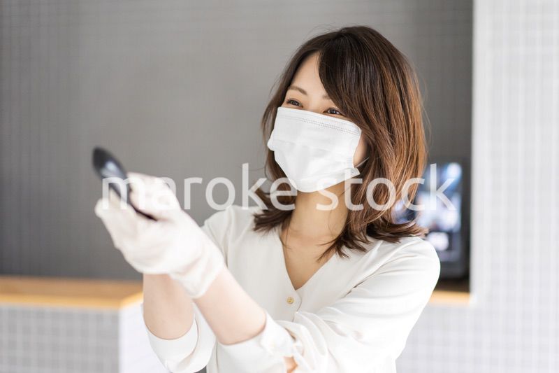 感染拡大防止のためにお客様の体温を計測するスタッフ