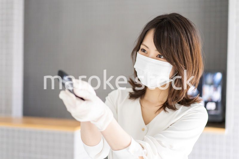 感染拡大防止のためにお客様の体温を計測するスタッフ