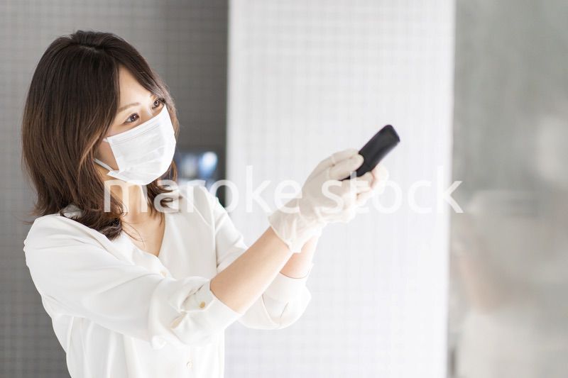 感染拡大防止のためにお客様の体温を計測するスタッフ