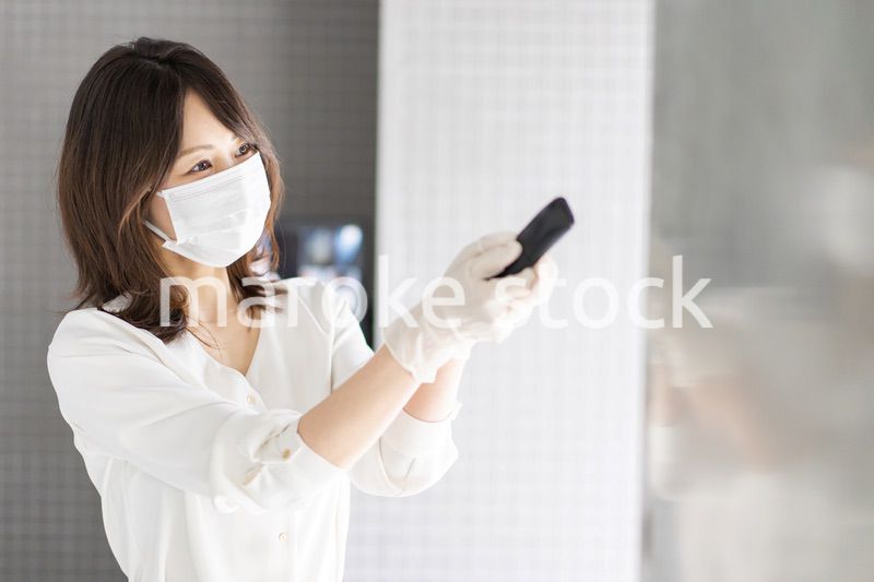 感染拡大防止のためにお客様の体温を計測するスタッフ