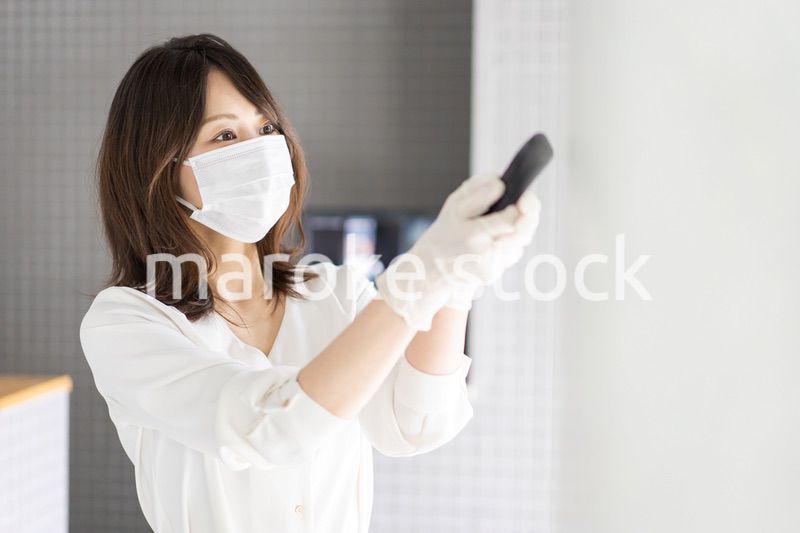 感染拡大防止のためにお客様の体温を計測するスタッフ