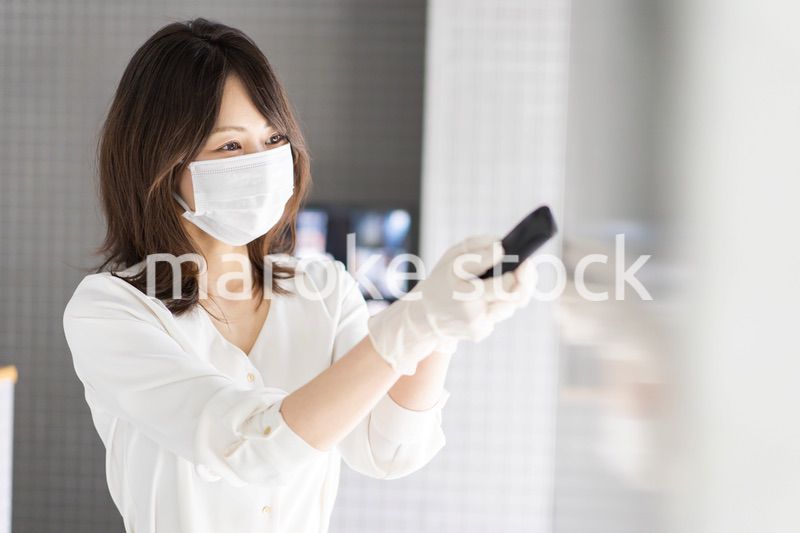 感染拡大防止のためにお客様の体温を計測するスタッフ