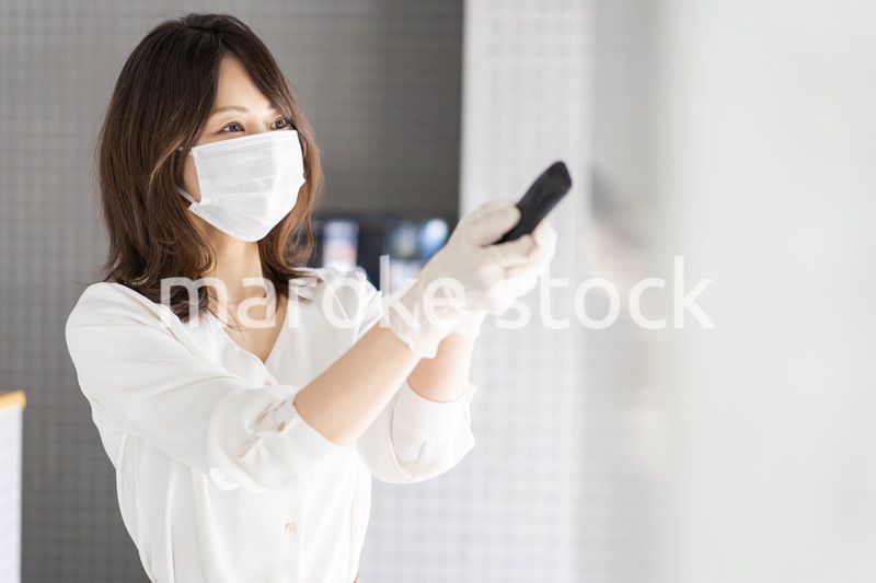 感染拡大防止のためにお客様の体温を計測するスタッフ