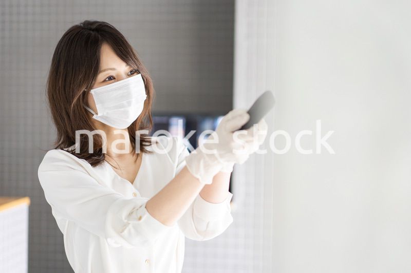 感染拡大防止のためにお客様の体温を計測するスタッフ