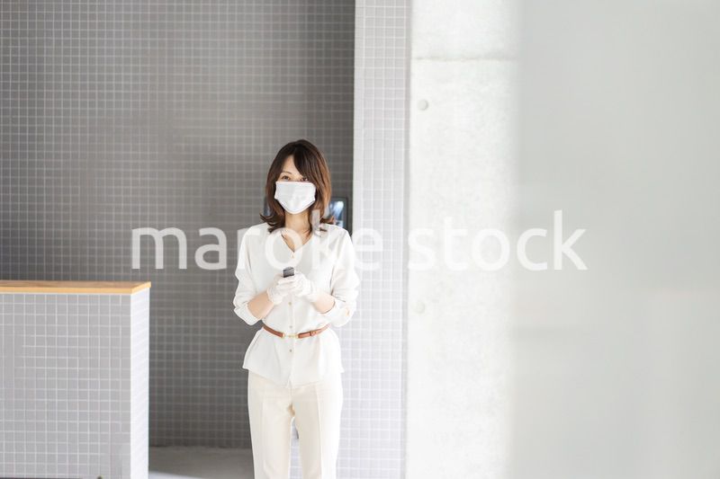 感染拡大防止のためにお客様の体温を計測するスタッフ