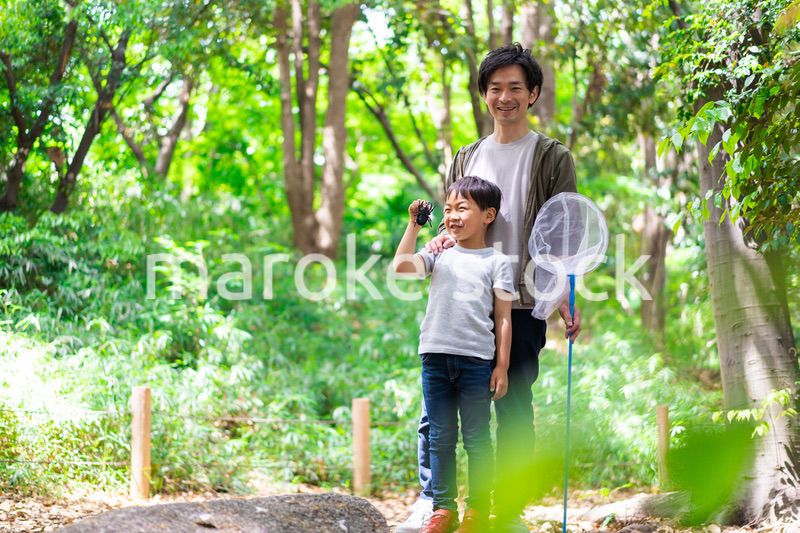虫取りをするお父さんと男の子