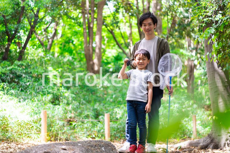 虫取りをするお父さんと男の子