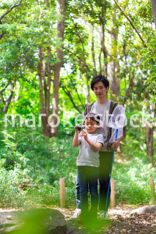 虫取りをするお父さんと男の子