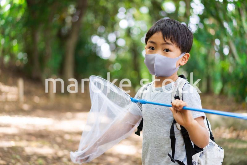 マスクをして外で遊ぶ少年