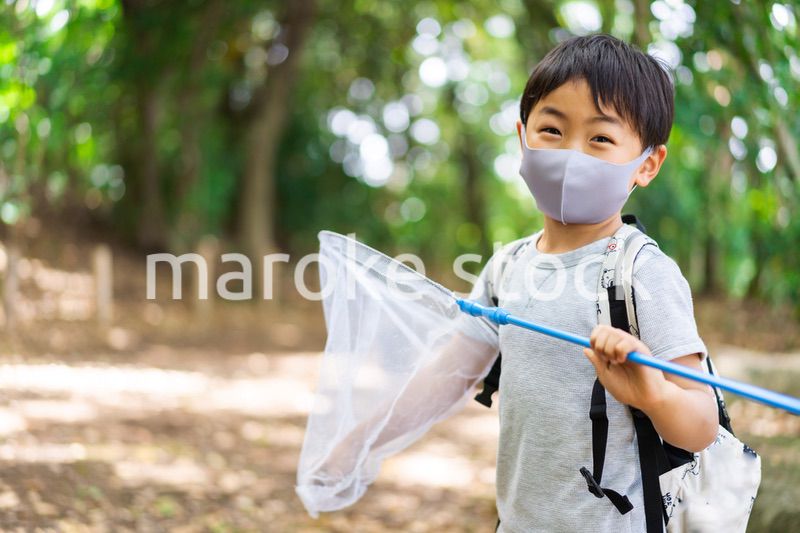 マスクをして外で遊ぶ少年