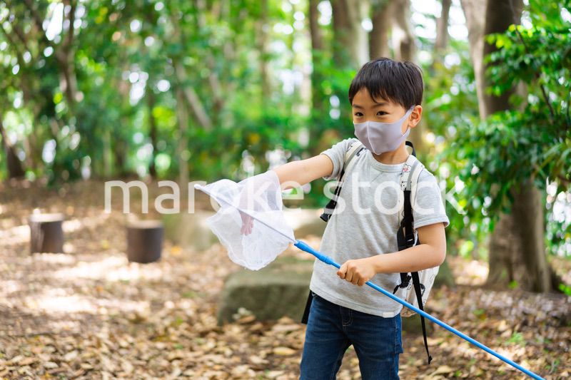 マスクをして外で遊ぶ少年