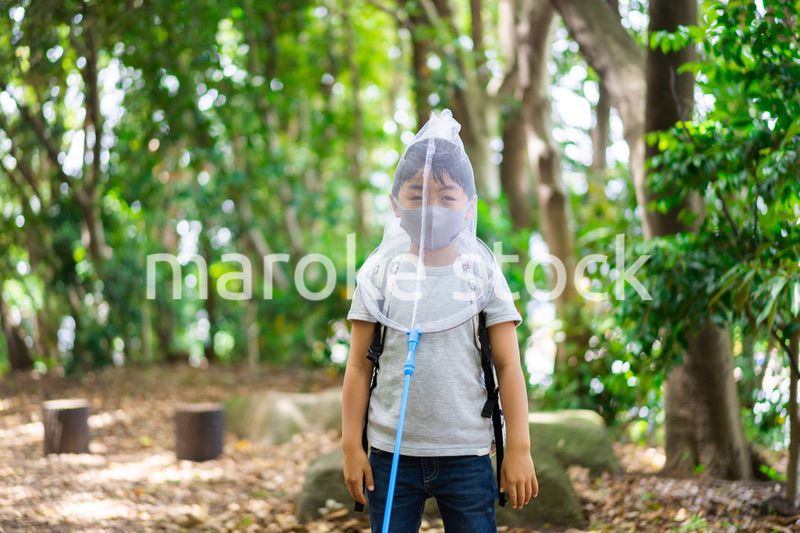 マスクをして外で遊ぶ少年