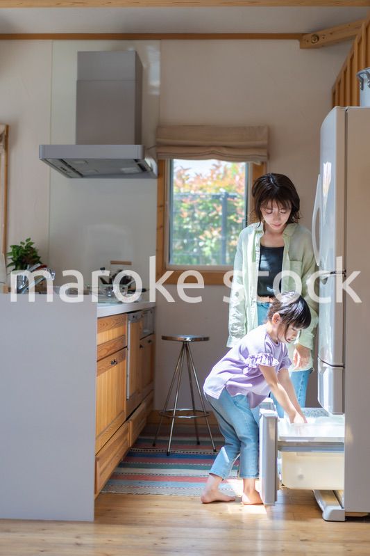 お母さんと一緒に料理をする小さな女の子