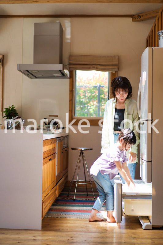 お母さんと一緒に料理をする女の子