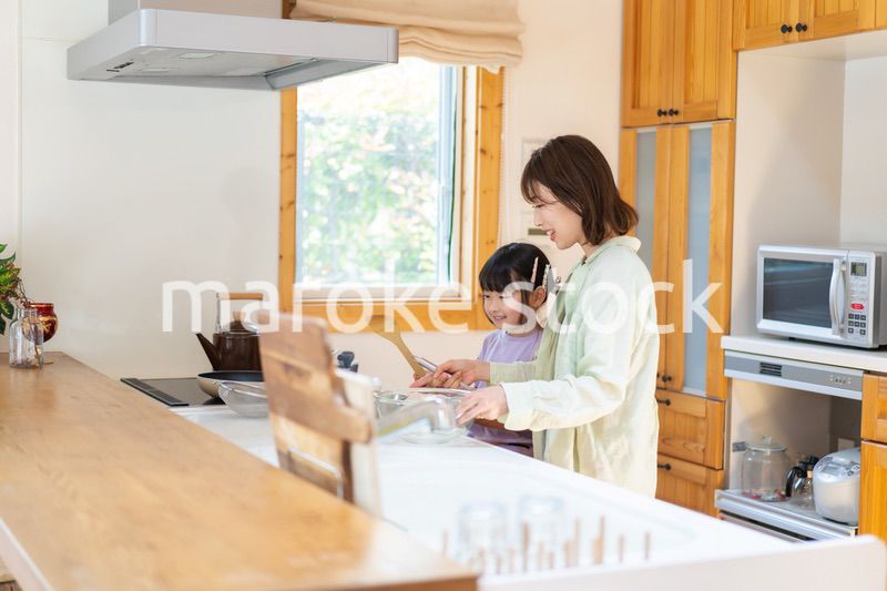 お母さんと一緒に料理をする小さな女の子