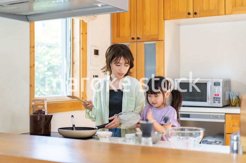 お母さんと一緒に料理をする小さな女の子