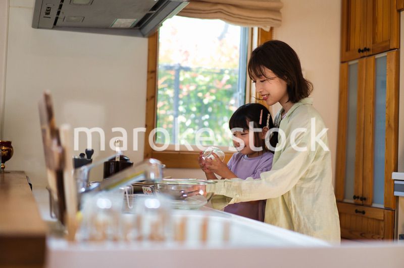 お母さんと一緒に料理をする女の子