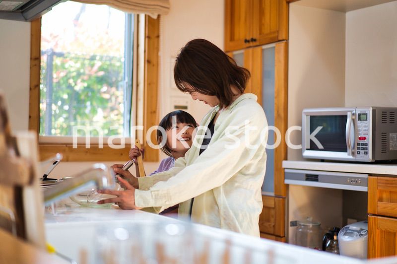 お母さんと一緒に料理をする女の子