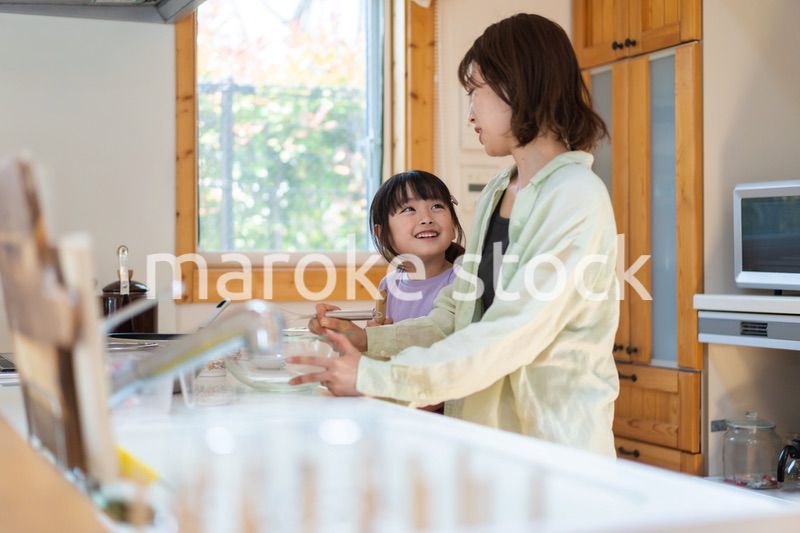 お母さんと一緒に料理をする小さな女の子