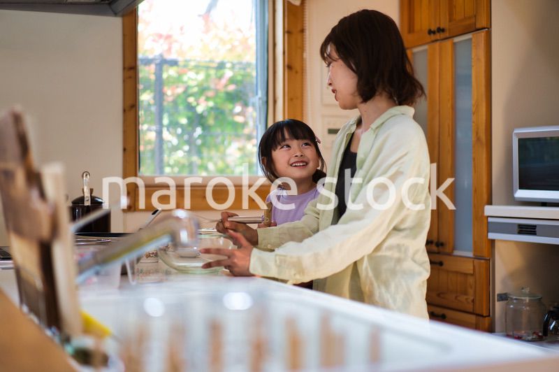 お母さんと一緒に料理をする女の子