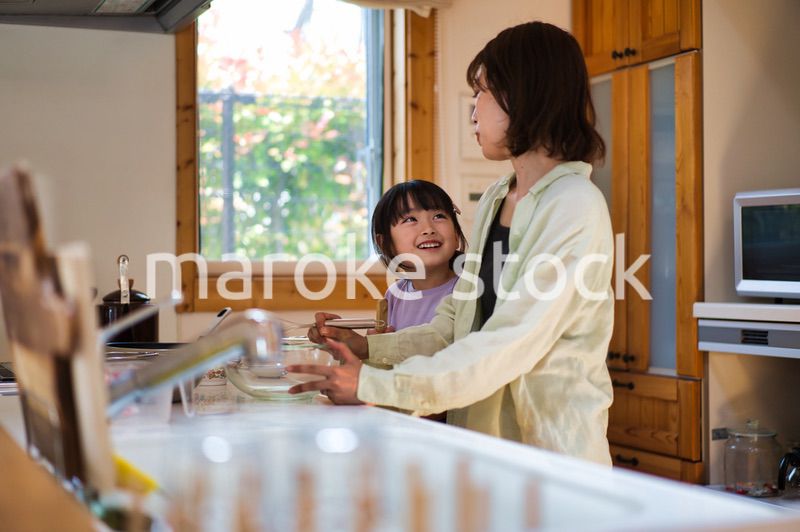 お母さんと一緒に料理をする女の子