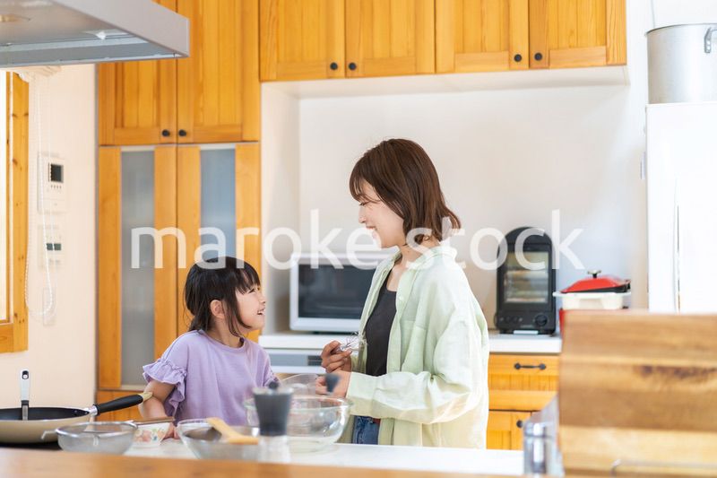 お母さんと一緒に料理をする小さな女の子