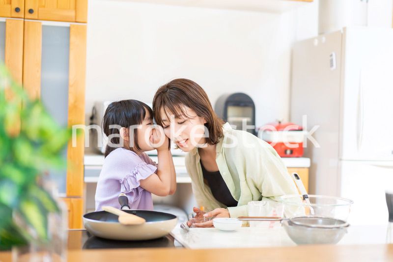 お母さんと一緒に料理をする小さな女の子