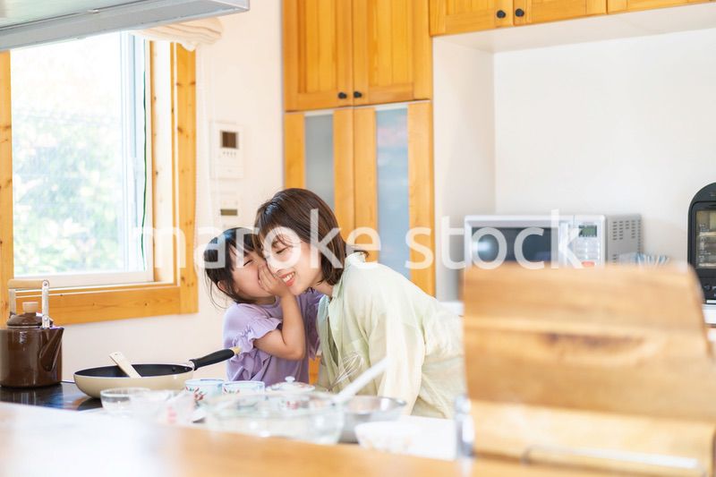 お母さんと一緒に料理をする小さな女の子