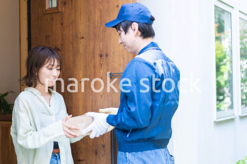 宅配便・デリバリーを受け取る若い女性