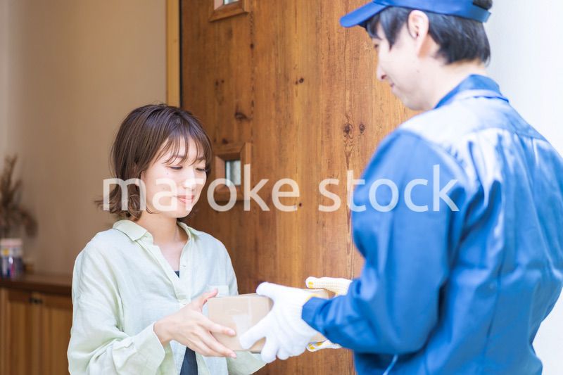 宅配便・デリバリーを受け取る若い女性