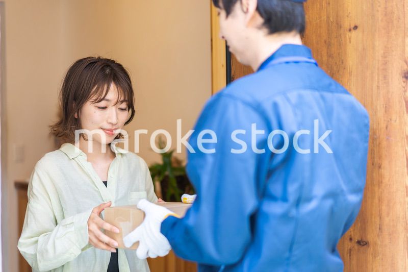 宅配便・デリバリーを受け取る若い女性
