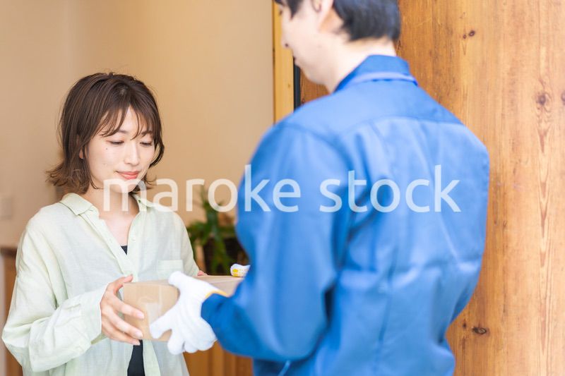 宅配便・デリバリーを受け取る若い女性