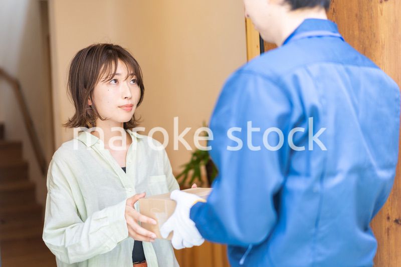 宅配便・デリバリーを受け取る若い女性