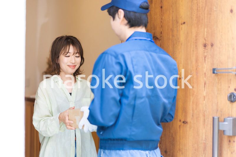 宅配便・デリバリーを受け取る若い女性
