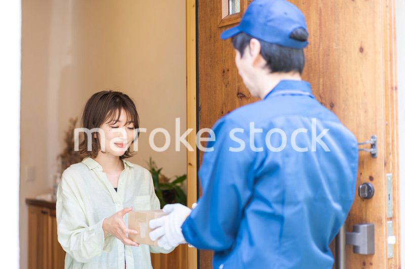 宅配便・デリバリーを受け取る若い女性