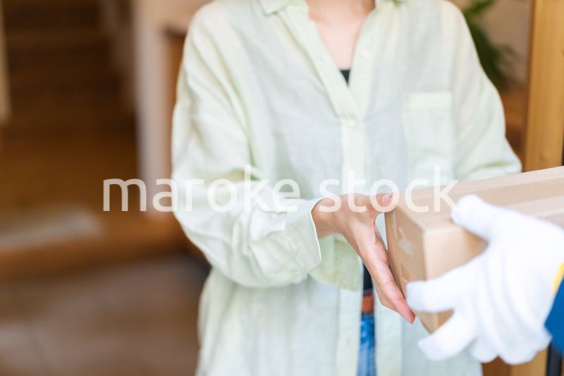 宅配便・デリバリーを受け取る若い女性