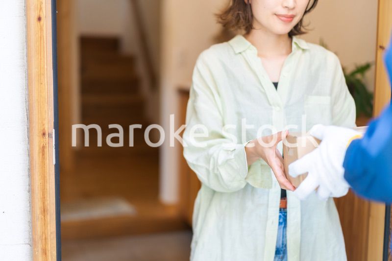 宅配便・デリバリーを受け取る若い女性