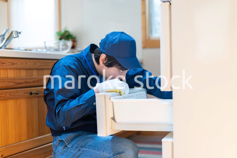 冷蔵庫の修理をする技術スタッフ