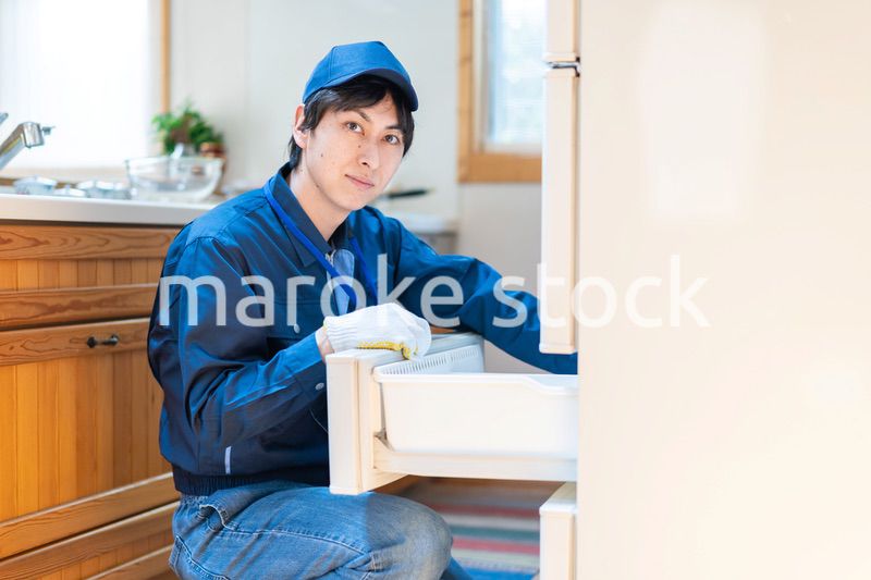 冷蔵庫の修理をする技術スタッフ