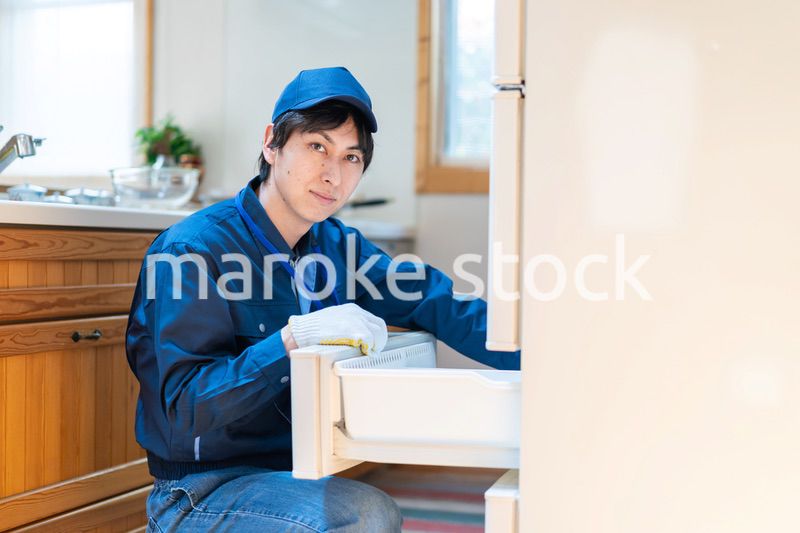 冷蔵庫の修理をする技術スタッフ