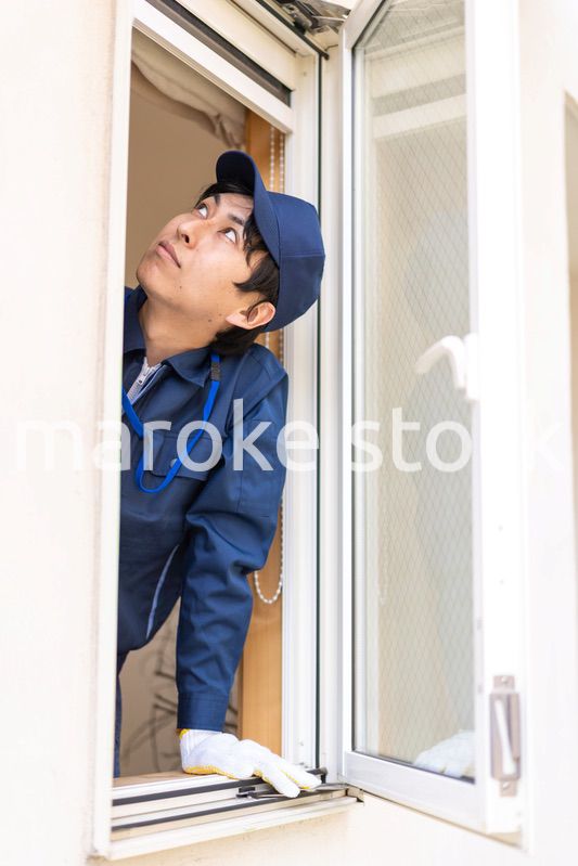 窓のメンテナンスをする技術スタッフ